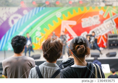 学園祭で大学生がバンドを演奏しているステージを見つめる人たち 学園祭で大学生がバンドを演奏しているステージを見つめる人たち 136493675