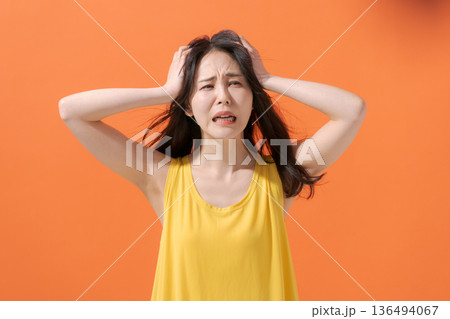 頭を抱えて叫ぶ女性 136494067