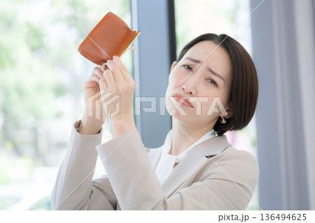 働いてもお金がない(金欠)の悲しい困ったイメージ 物価高大変だな～今月も赤字かな？カメラ目線 136494625