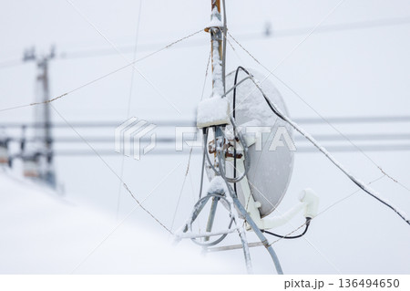 雪が付着したパラボラアンテナの背面と配線(受信障害イメージ) 雪が付着したパラボラアンテナの背面と配線(受信障害イメージ) 136494650
