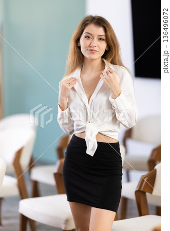 Girl playfully poses in classroom or lecture hall 136496072