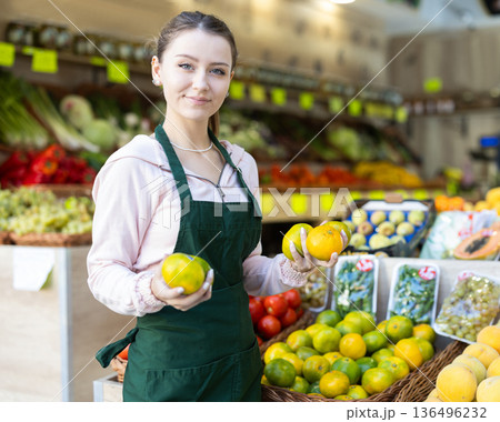 Portrait of girl working in grocery shop as job experience, selling lime Portrait of girl working in grocery shop as job experience, selling lime 136496232