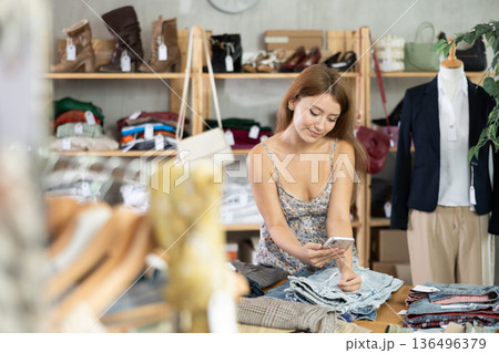 Young woman scanning barcode of jeans in store 136496379