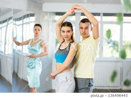 Positive man and woman practicing samba in dance class Positive man and woman practicing samba in dance class 136496443
