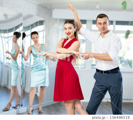 Couple in stage costumes learns waltz dancing during individual lesson 136496519