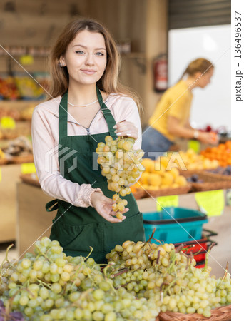 woman shopping assistant selling grape in supermarket 136496537