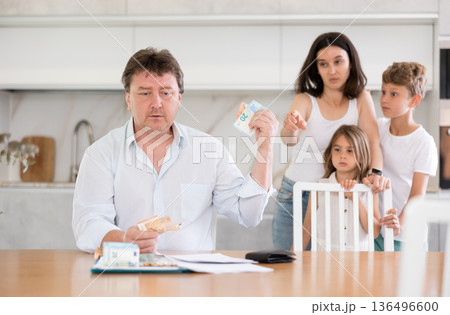 Father gives pocket money to children and wife Father gives pocket money to children and wife 136496600