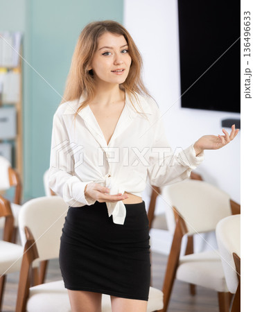 Young woman secretary invites to lecture hall 136496633