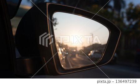Mirror view of car black color. Inside glass can see traffic in the morning with clear road and sunrise. 136497239