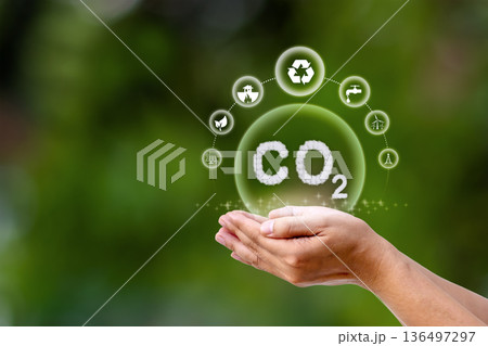 The CO2 symbol, or carbon dioxide, in the hand represents reducing carbon dioxide emissions, one of the greenhouse gases, reflecting the concept of sustainable environmental practices. 136497297