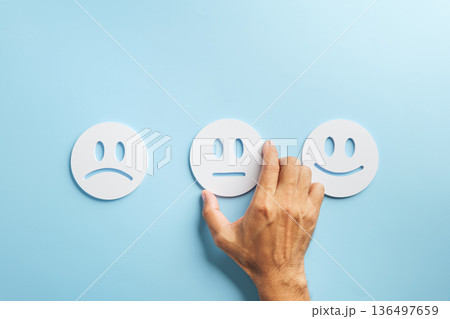 Customer feedback concept, hand selecting neutral face from range of happy neutral and sad expressions for satisfaction survey experience, demonstrating service review rating choice Customer feedback concept, hand selecting neutral face from range of happy neutral and sad expressions for satisfaction survey experience, demonstrating service review rating choice 136497659