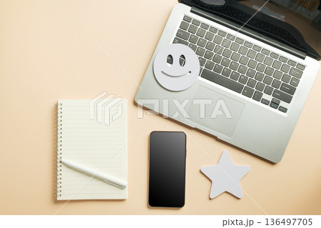 Online customer feedback for laptop and phone review, blank notebook offers space for assessment, star and happy face emoji symbolize client satisfaction digital survey Online customer feedback for laptop and phone review, blank notebook offers space for assessment, star and happy face emoji symbolize client satisfaction digital survey 136497705