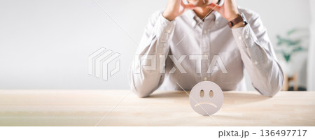 Customer shows unhappy feedback, reflecting low satisfaction, bad review icon sits on desk as person ponders complaint, considering poor service and overall experience Customer shows unhappy feedback, reflecting low satisfaction, bad review icon sits on desk as person ponders complaint, considering poor service and overall experience 136497717