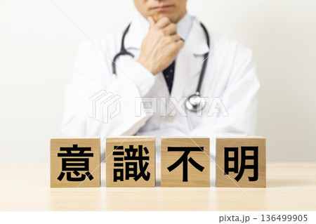 「意識不明」と書かれたブロックと悩む医師 136499905