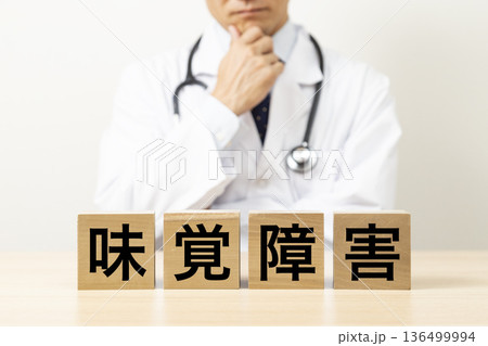「味覚障害」と書かれたブロックと悩む医師 136499994