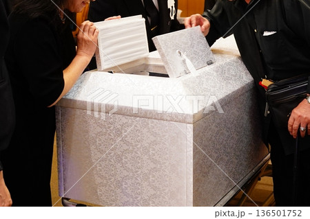 棺の小窓を閉じる遺族 136501752