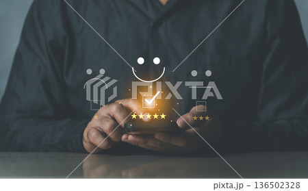 Close-up of a Person Interacting with Smartphone and Icons Representing Feedback and Customer Satisfaction in a Modern Conceptual Setting 136502328