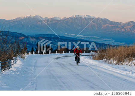 厳冬の高原に続く凍結路を上るサイクリスト 136505945