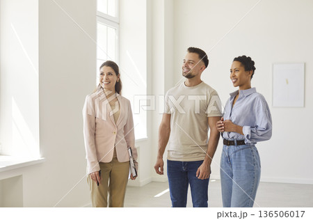 Real estate agent, realtor presenting young couple modern indoor space, professional consultation Real estate agent, realtor presenting young couple modern indoor space, professional consultation 136506017