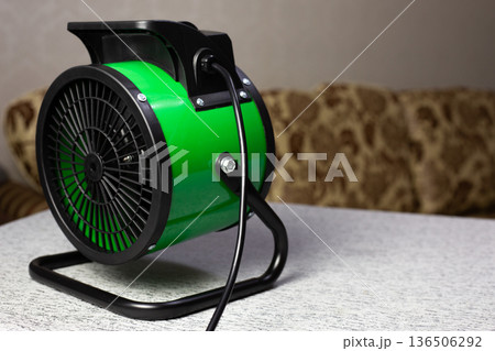 Fan powered heater heats room with stream of hot air. This helps warm the room and improves winter comfort. Solving your heating problem with portable heater. Indispensable device for home Fan powered heater heats room with stream of hot air. This helps warm the room and improves winter comfort. Solving your heating problem with portable heater. Indispensable device for home 136506292