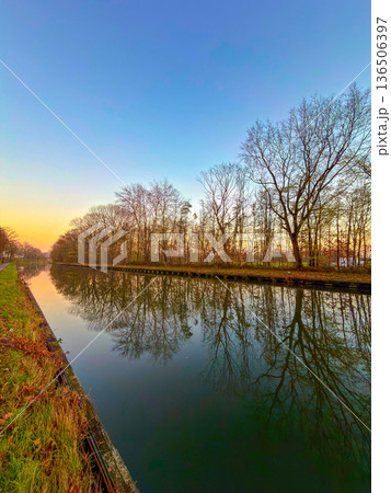 Rijkevorsel, Antwerpse Kempen, Belgium, Golden hour canal with mirrored trees photographers pause Rijkevorsel, Antwerpse Kempen, Belgium, Golden hour canal with mirrored trees photographers pause 136506397