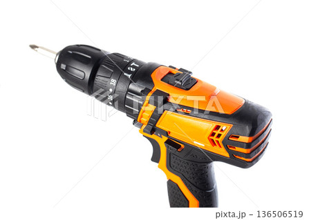 Cordless drill screwdriver with orange and black body, visible drill chuck and removable bit, power tool equipment for home improvement and construction 136506519