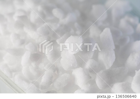 White crystalline substance close up showing irregular shapes and rough textures of granular material for water softening or industrial use. White crystalline substance close up showing irregular shapes and rough textures of granular material for water softening or industrial use. 136506640