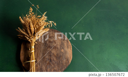 Wheat ears on a green background copy space. Dried Grasses on Wooden Board Wheat ears on a green background copy space. Dried Grasses on Wooden Board 136507672