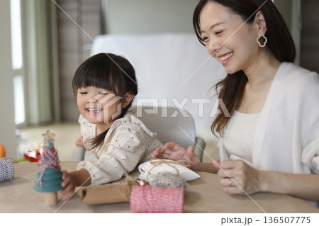 小さなクリスマスツリーに飾りを付ける親子 小さなクリスマスツリーに飾りを付ける親子 136507775