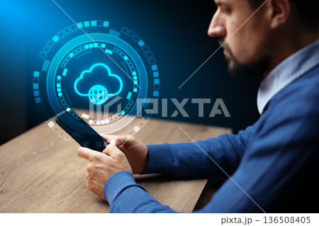 Man using smartphone with cloud technology concept displayed on screen during evening 136508405