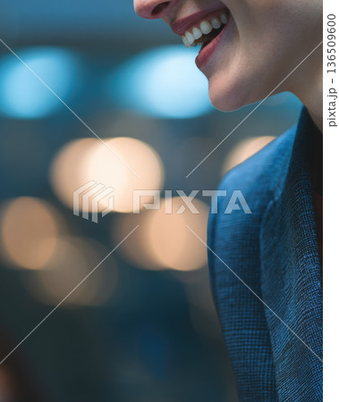 Inclusive leadership meeting atmosphere with smiling professional in blue suit jacket showing positive emotion and engagement in modern office environment 136509600