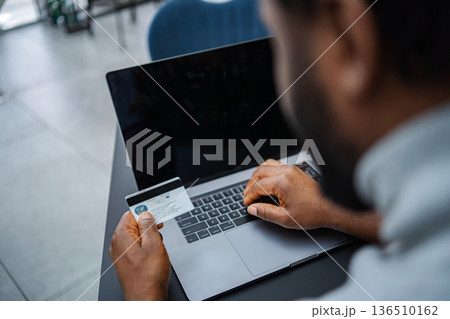 Person doing online shopping using credit card and laptop 136510162