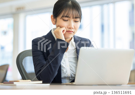 パソコンの画面を見ながら悩む女性 パソコンの画面を見ながら悩む女性 136511691
