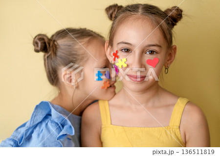 Stickers in the form of multicolored puzzles on the face of children with autism.  Special education in schools with special children with autism spectrum disorder 136511819