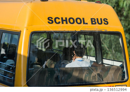 Rear view of yellow school bus with students inside, in Jaipur, Rajasthan, India 136512994