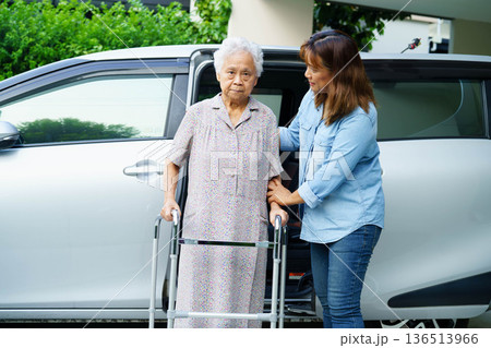 Caregiver help Asian elderly woman disability patient use walker to get in car. 136513966