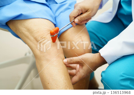 Asian doctor knock on knee reflex nerve for check and treatment senior patient in hospital. 136513968