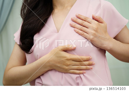 Asian woman self touching check lump or Breast cancer, Breast Self Exam. 136514103