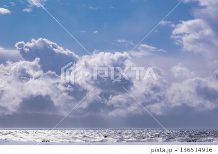 冬の晴れた海と雲:日差しに輝く波と海沿いのベンチ 冬の晴れた海と雲:日差しに輝く波と海沿いのベンチ 136514916