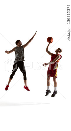 Basketball player driving to basket while opponent defends isolated on white background. Basketball player driving to basket while opponent defends isolated on white background. 136515375