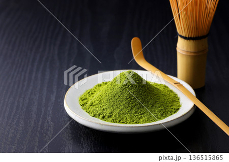 黒い木目背景に映える鮮やかな緑の抹茶の粉末 136515865