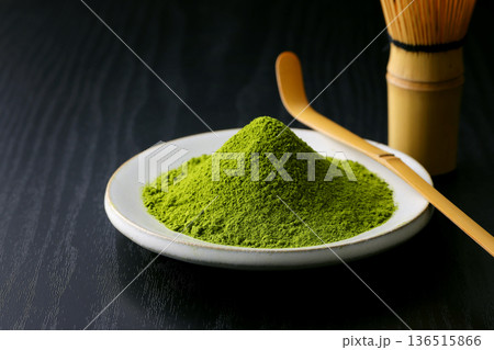 黒い木目背景に映える鮮やかな緑の抹茶の粉末 136515866