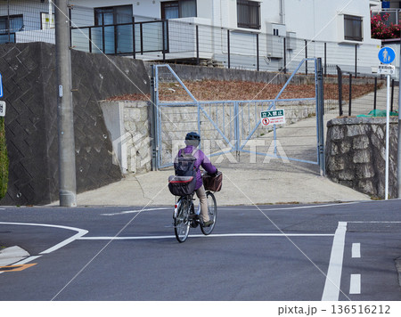 冬の住宅街で自転車を乗る中年女性の姿	 136516212