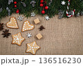 Christmas natural background. Gingerbread cookies, pine needles, anise, holly berries, cones, lump sugar on canvas background, copy space. 136516230