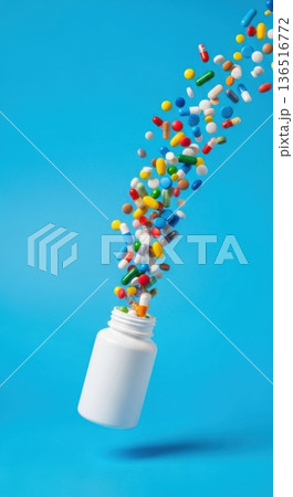 Colorful Medical Capsules Flying Out of White Pill Bottle 136516772