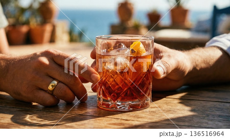 Refreshing Negroni Cocktail Held Over Mediterranean Sea View 136516964