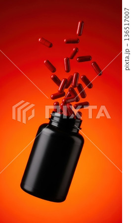Explosion of Red Capsules Flying Out of Black Supplement Bottle 136517007