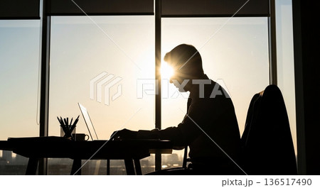 窓際でノートパソコンを操作する男性社員 136517490