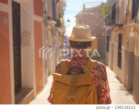 Woman strolls through colorful streets of Spanish coastal town Woman strolls through colorful streets of Spanish coastal town 136518225