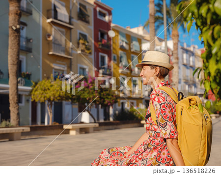 Woman strolls through colorful streets of Spanish coastal town Woman strolls through colorful streets of Spanish coastal town 136518226